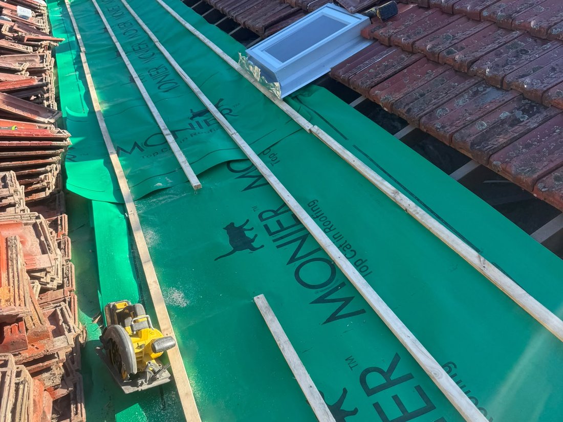 Monier roof sarking laid across a stripped roof section with new timber battens fixed over it